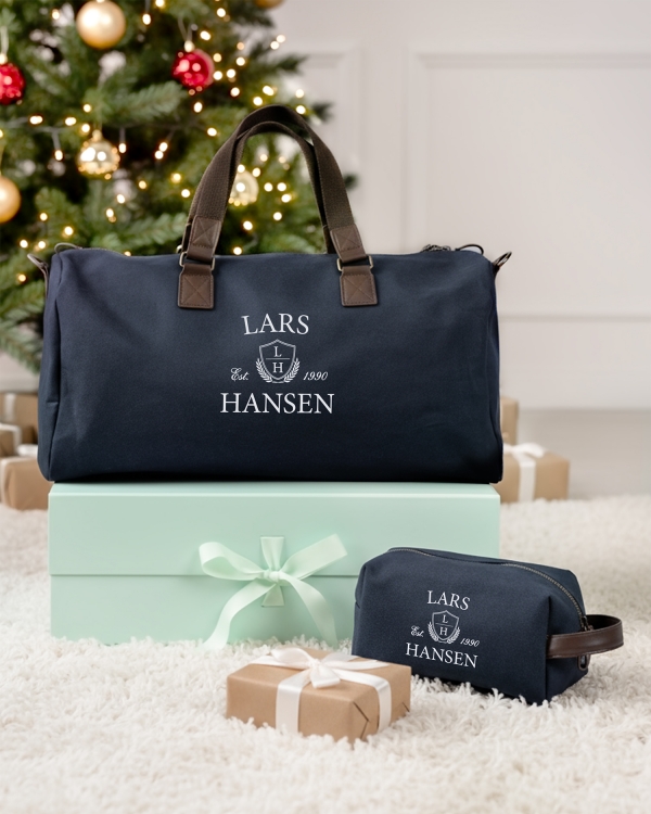 Julegaveidé til ham med marineblå duffeltaske og toilettaske, der personliggøres med valgfrit navn.