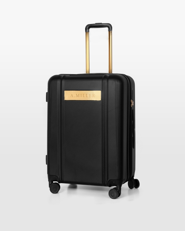 Sort kuffert med navn og gulddetaljer