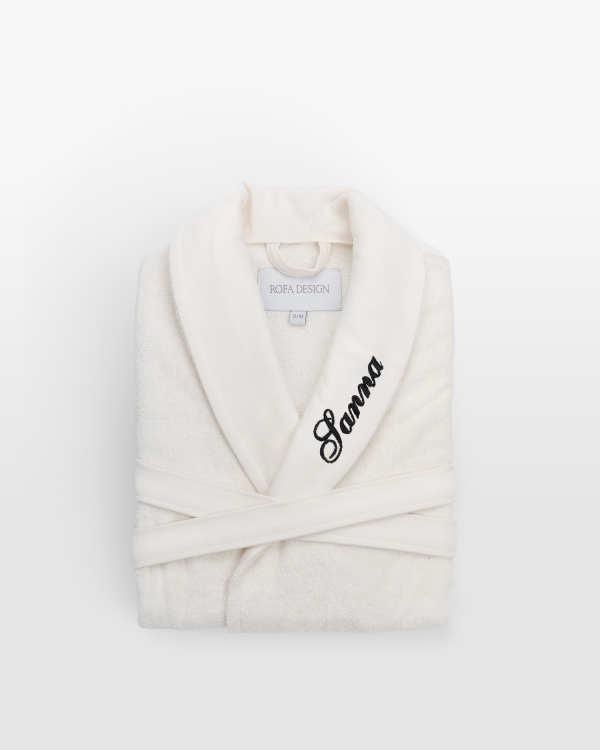 Moderne cremefarvet børnebadekåbe med personligt sort broderi, ideel til trendy komfort for børn.