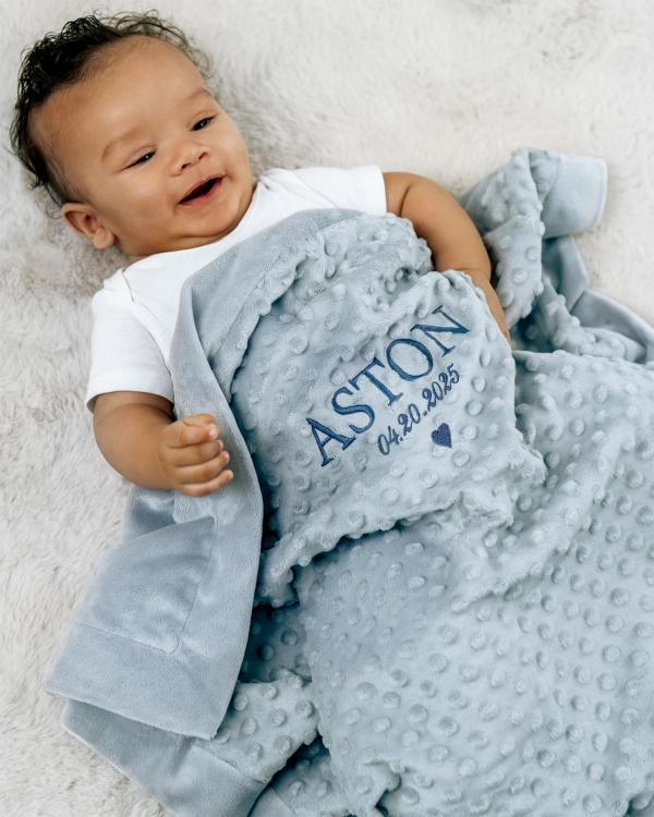 Hyggeligt blåt tæppe med broderet navn og dato