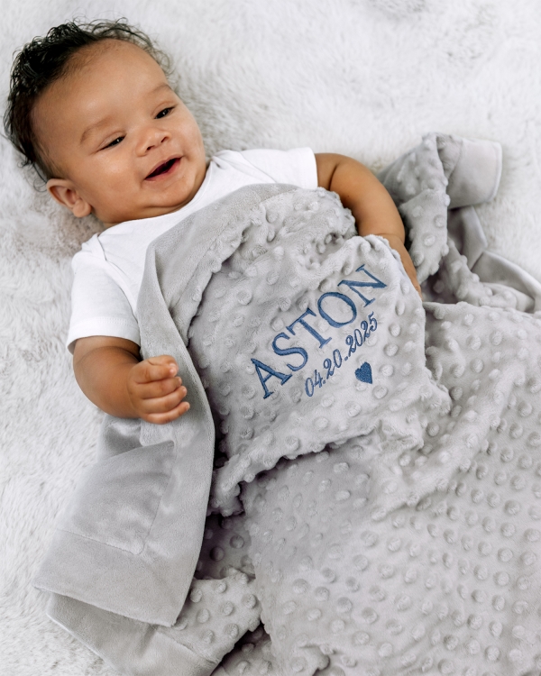 Hyggeligt gråt tæppe med broderet navn og dato