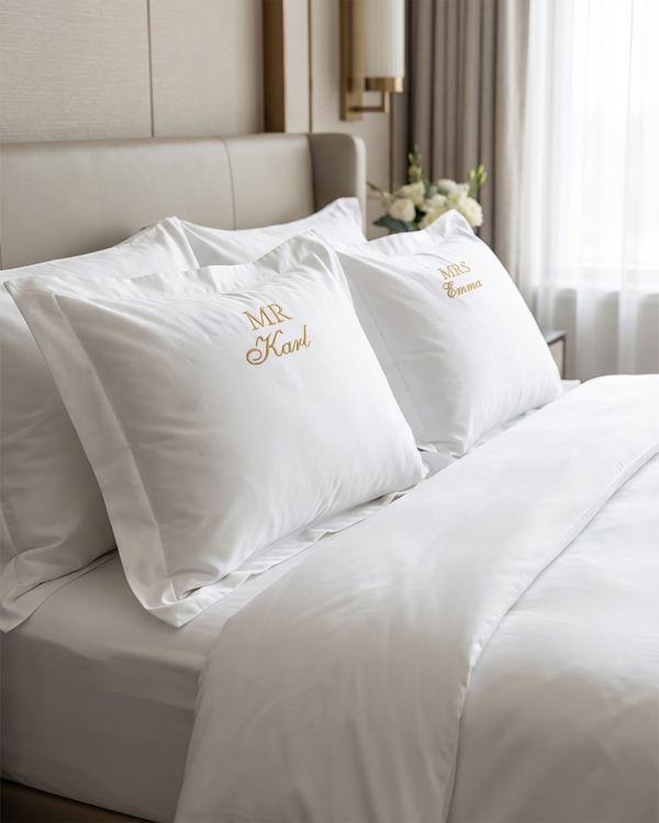 Hvidt dynebetræk med broderet tekst til brudeparret