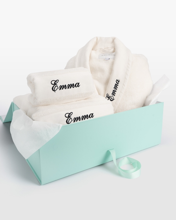 Cremefarvet håndklædesæt med badekåbe og personligt sort broderi, perfekt til moderne komfort og elegance.